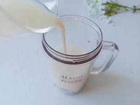 加牛奶至榨汁杯的八分满。