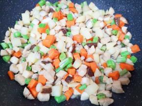 下入土豆、胡萝卜、香菇、豆角和黑豆翻炒均匀