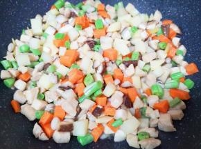 下入土豆、胡萝卜、香菇、豆角和黑豆翻炒均匀