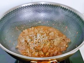 加入1汤勺纯净水，烧开撒上熟白芝麻，大火快速翻炒。