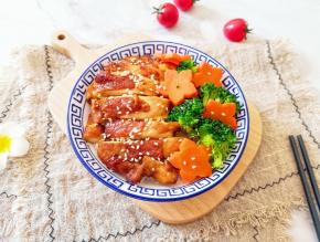 碗里装入米饭，摆上鸡腿肉、西蓝花和胡萝卜花，撒上熟白芝麻。