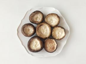 把香菇洗净，用剪刀把香菇柄剪掉。翻过来放好。