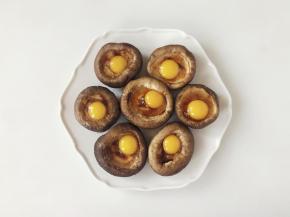 然后把鹌鹑蛋磕入香菇碗中，一个香菇搭配一个鹌鹑蛋。