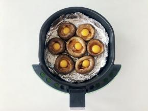 空气炸锅的炸篮里垫上锡纸，然后把香菇碗放进去。香菇在烤制的时候会出水，垫锡纸方便清洗。