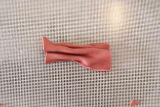 再将剩余的深红色干佩斯擀平，切一个小长方形，捏少许的褶皱。