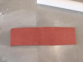 制作蝴蝶结：熟玉米淀粉和糖粉混合，撒少许在防粘垫上，深红色干佩斯擀成1-2毫米厚的薄片，切成长方形。