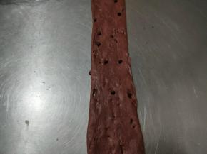 取一个擀卷的面团，将其用手掌轻轻压扁，再次用擀面杖轻轻的擀长，这次要比之前的更加细长。