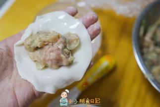 准备一张饺子皮，放入满满的肉馅，边缘蘸一圈水