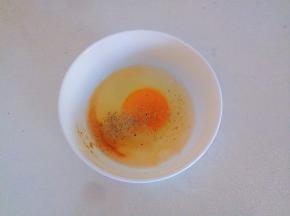 鸡蛋磕入碗中，加入盐、料酒、胡椒粉、两滴醋搅拌均匀。