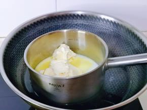 牛奶与奶油奶酪加入奶锅中，小火隔水融化，同时一边用手动打蛋器搅拌。