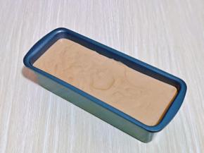 将蛋糕糊倒入模具中，轻轻震出气泡。