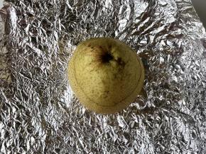 把雪梨的盖子盖好，放到锡纸中间。