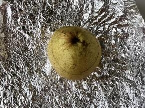 把雪梨的盖子盖好，放到锡纸中间。