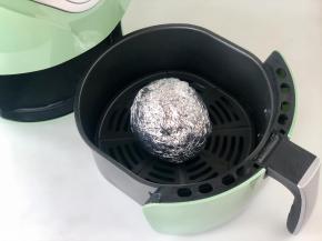 把包好的梨子放入炸锅，推入机器中。