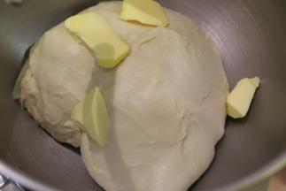 启动和面程序，揉成光滑能拉出有弹性的薄膜后放入黄油。