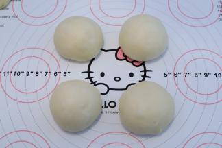 面团取出轻压排气，平均分成4份，分别搓圆，静置15分钟。