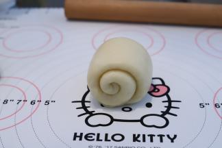 再次将面团擀成牛舌状，翻面从上往下卷。