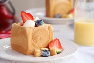 用小的冰淇淋勺挖两勺冰淇淋摆放上去，再放上草莓和蓝莓装饰。