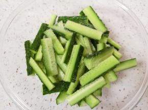 将黄瓜条放入盆里，撒上一点盐搅拌均匀，腌制一下。