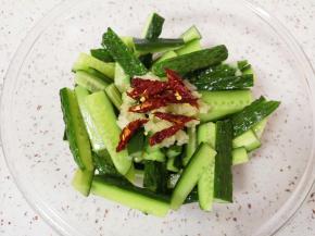 黄瓜条倒掉腌制出来的水分，放上蒜泥和辣椒丝。