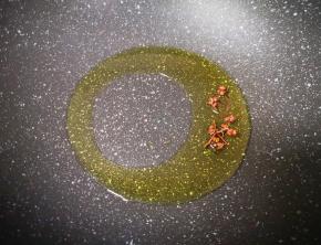 炒锅内倒入食用油烧至微微冒烟，下入花椒粒炸香，捞出不要。