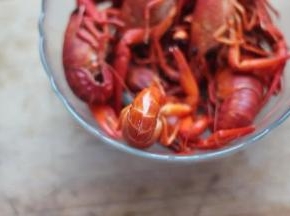 4，龙虾入开水中煮熟。小龙虾的尾部用剪刀剪一条缝，以便做时入味