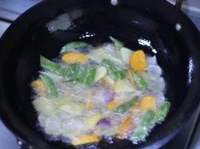 5，锅中入油烧热，加入土豆、豆角、胡萝卜中火炸到五成熟再放洋葱炸，炸到表皮金黄色捞出备用