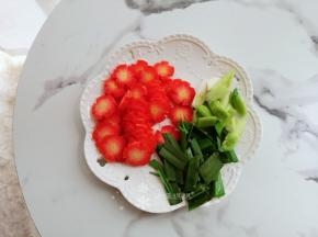 将胡萝卜切片、蒜苗切小段并将根茎和叶子分开放。