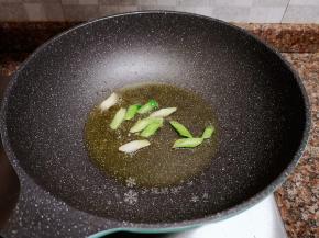 放入蒜苗头炒香。