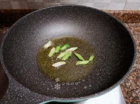放入蒜苗头炒香。