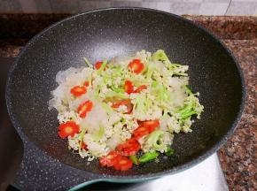 放入花菜、胡萝卜和银耳翻炒片刻。