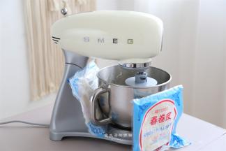 揉面桶放进厨师机卡口里卡紧，启动低速揉2分钟，再转3档揉5分钟，粗膜后加入黄油，1档揉吸收后再3档揉5分钟即可，天气炎热的时候要绑冰袋降温，我家没有冰袋了，用冷冻的春卷皮也行！