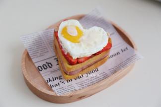 将培根肉切半，放在面包片上，挤上沙拉酱，再放一片面包，放上适量的水果和一个煎鸡蛋，挤上沙拉酱，放一块芝士片。