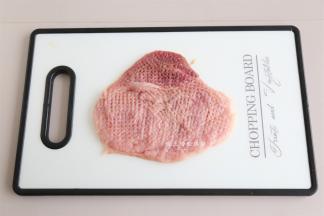猪排用保鲜膜装好，用松肉锤轻轻的敲打成大约1CM高度的肉片，我用170克猪里脊，做了两块炸煮排。