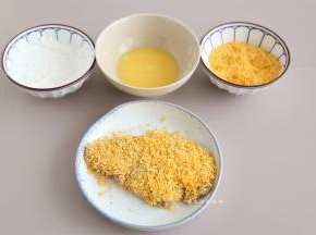 接着处理猪排，鸡蛋打入碗里，搅拌成蛋液，将猪排按照淀粉，蛋液，面包糠的次序均匀的沾上，每一个调料都要沾均匀。