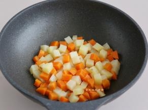 热锅，放入适量的油，爆香蒜末后倒入土豆和胡萝卜块，翻炒1分钟左右。