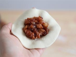 取一个面团，擀成中间厚旁边略薄的面片，放上适量的馅料，包起来，褶子捏得好看更有食欲哦！
