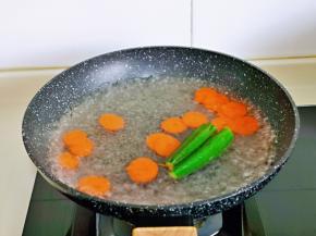 焯水，水烧开后加入胡萝卜片与秋葵，大火烧开煮1分钟捞出。