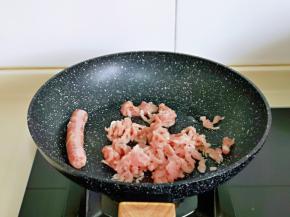 起油锅，加入肉丝及牛肉香肠，小火翻炒。