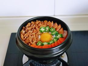 鸡蛋磕再中间，把胡萝卜片及秋葵摆入砂锅中，加入辣酱，小火烧熟即可。(全程小火)
