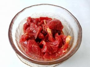 带上手套把牛肉抓匀，这样才会更入味。再淋一勺食用油抓匀，锁住调味料和水分，腌制 15 分钟。