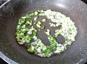 锅里加油下葱花与蒜末炒香。