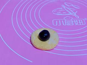 取一块糯米团，用掌心压扁，再放上准备好的豆沙馅，包子手法包起来，揉圆，压扁。