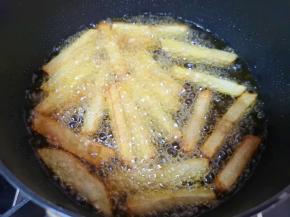 土豆条用厨房用纸吸干多余的水分，炸锅内倒入多一点食用油烧热，下入土豆条炸至金黄色捞出。