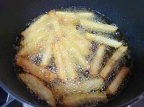 土豆条用厨房用纸吸干多余的水分，炸锅内倒入多一点食用油烧热，下入土豆条炸至金黄色捞出。