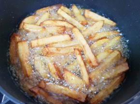 油继续烧至微微冒烟，下入土豆条复炸1分钟左右，捞出控油备用。