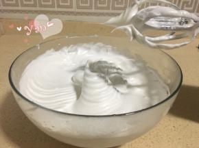 取出冷冻（或冷藏）的蛋清，分三次加入糖打发至提起打蛋头呈直立的小小弯钩状态。