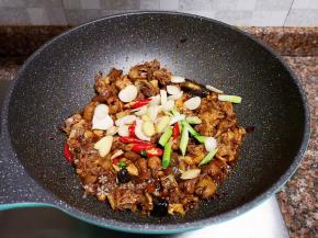 放入大蒜、生姜、小辣椒和蒜苗头翻炒出香味。