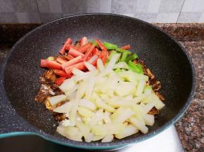 放入土豆、莴苣和胡萝卜条翻炒片刻。