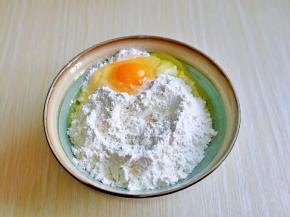 加入一个鸡蛋搅拌均匀，再分次加入温水，虽然有写出水量，但是由于不同面粉吸水性不同，所以需要自己来调整，水一定要分次加入，一边用筷子搅拌成絮状无干粉即可。